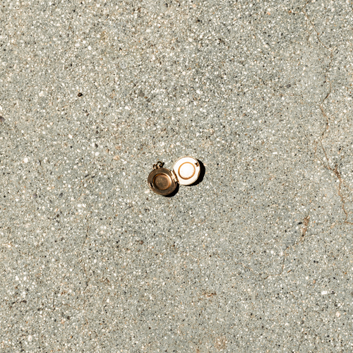 Two gold rings on a concrete surface