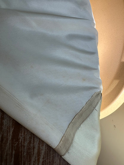 Close-up of a white fabric surface with a wooden texture underneath