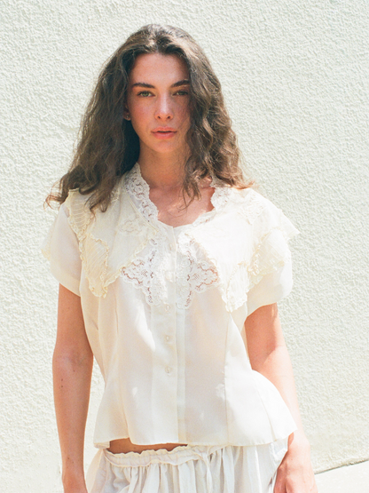 Woman wearing a white lace dress against a white background