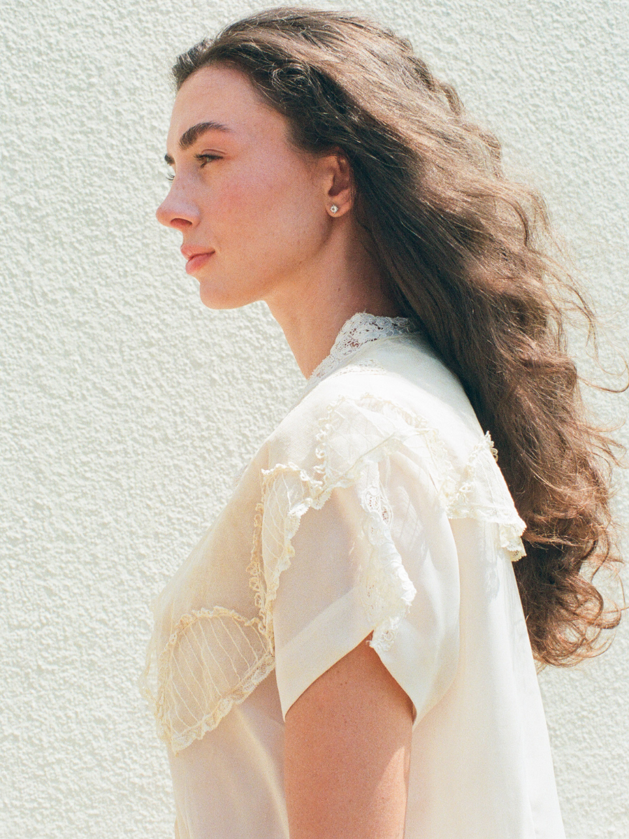 Woman wearing a white blouse against a light background