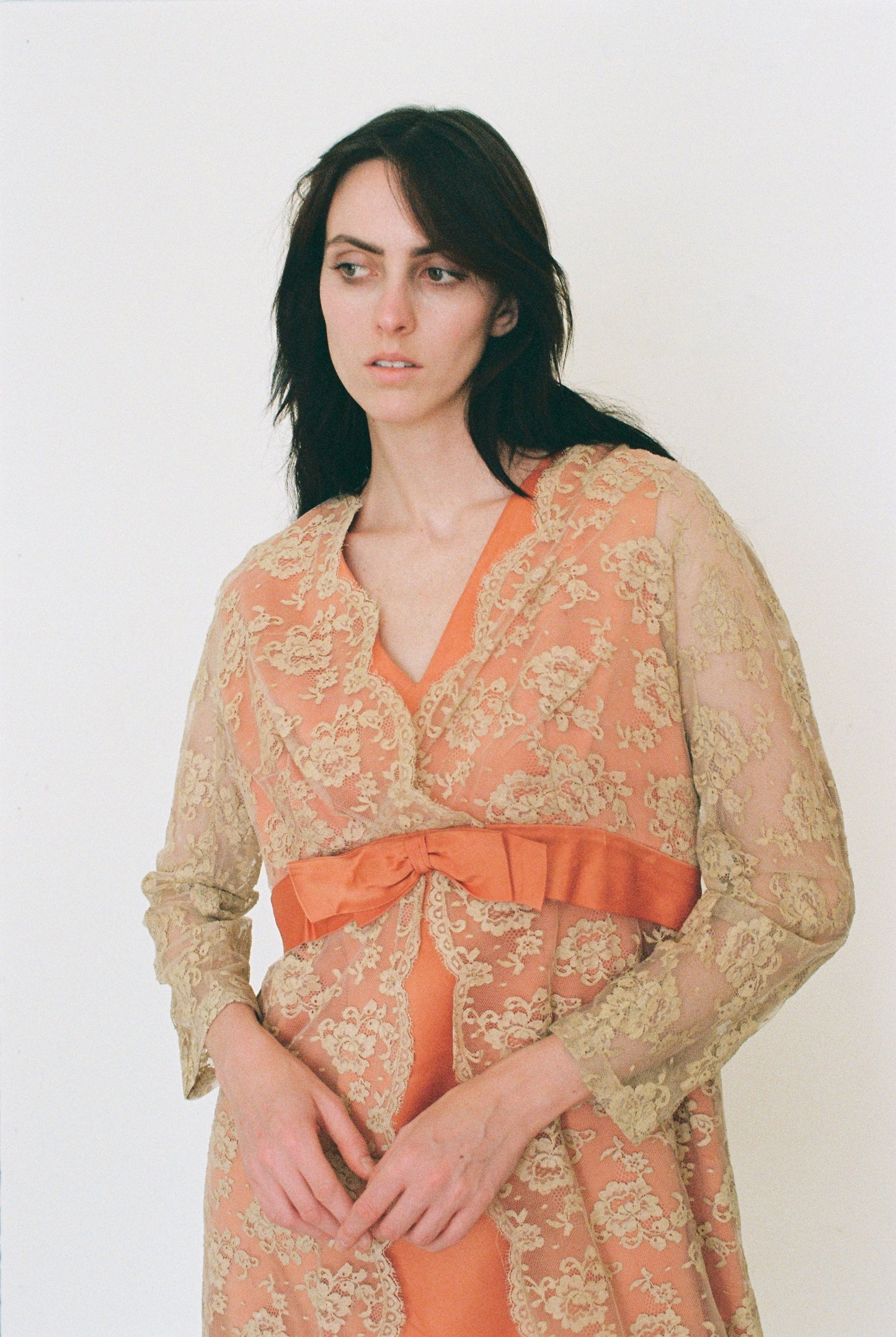 Woman wearing a patterned dress with a bow detail on a white background