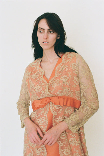 Woman wearing a patterned dress with a bow detail on a white background