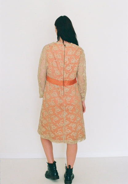 Person wearing a floral dress with a red belt against a white background