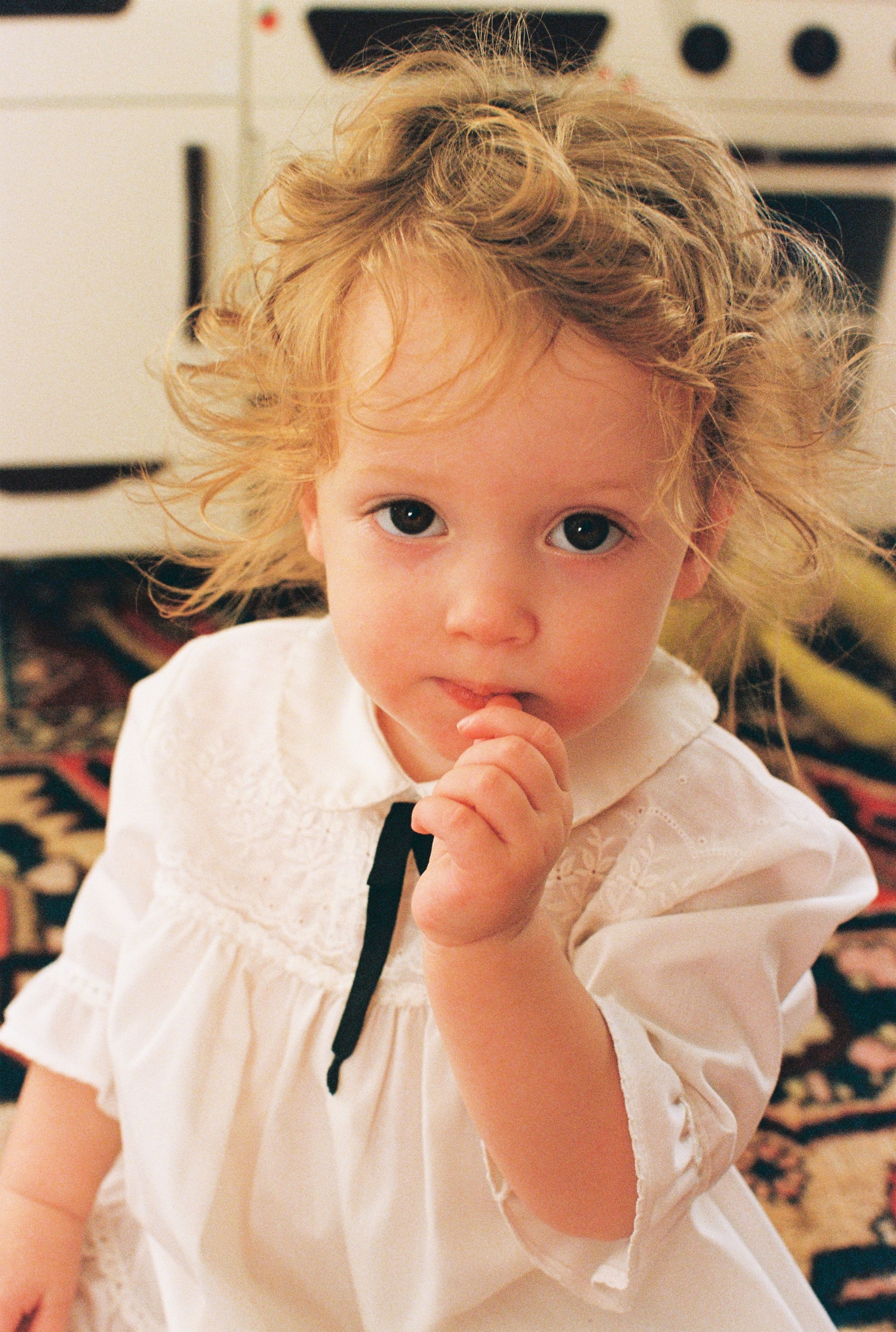 Young child in a  vinage white dress with a blurred background