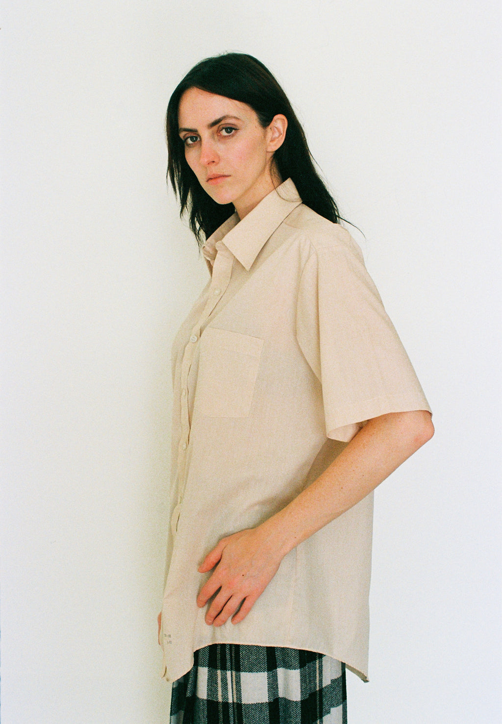 Woman wearing a beige shirt with a white background