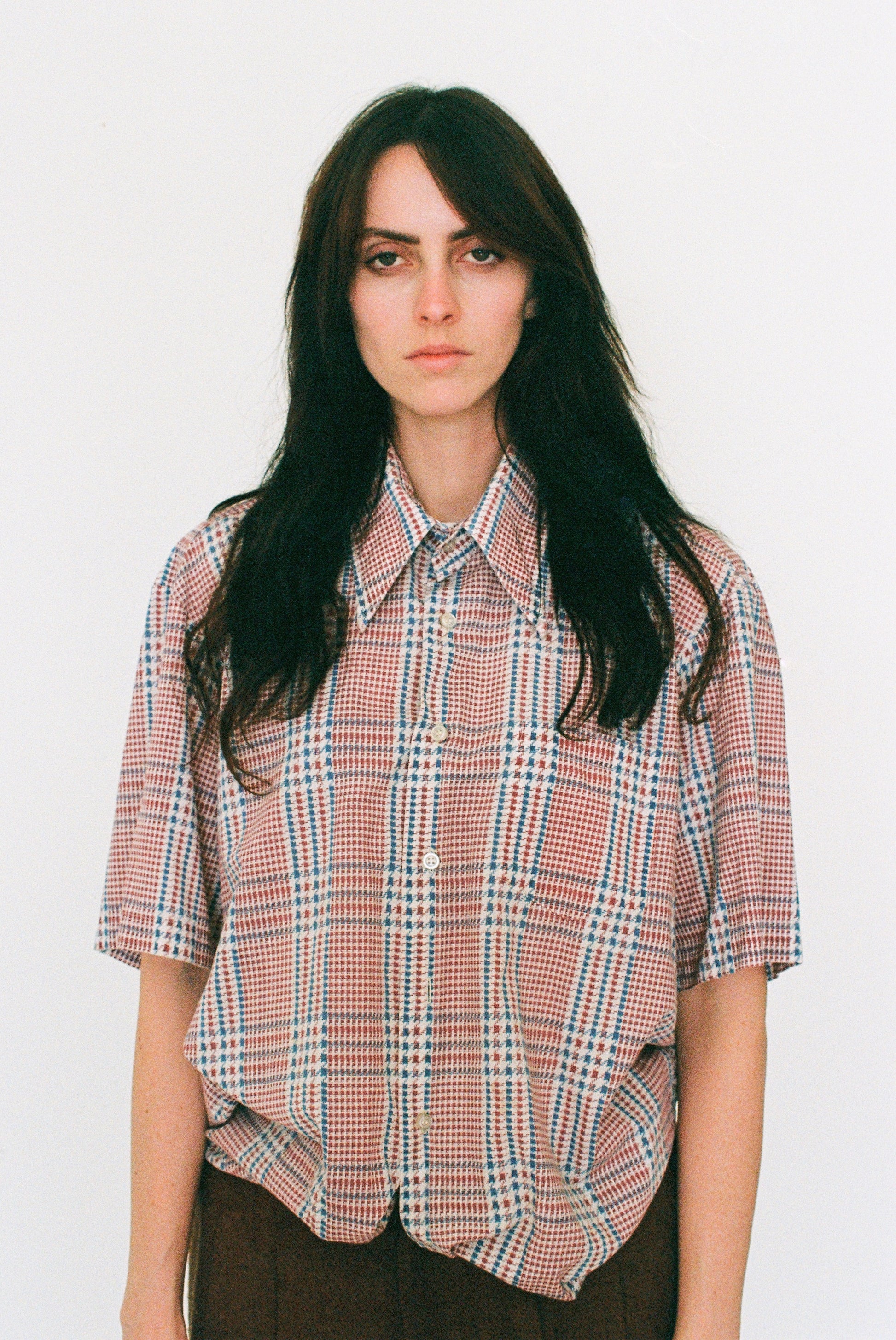 Person wearing a plaid shirt against a white background