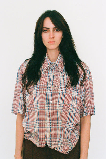 Person wearing a plaid shirt against a white background