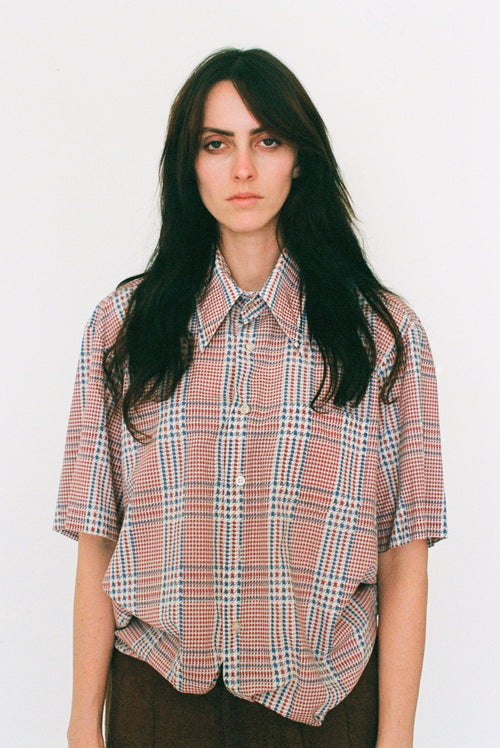 Person wearing a plaid shirt against a white background