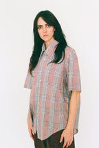 Person wearing a plaid shirt on a white background