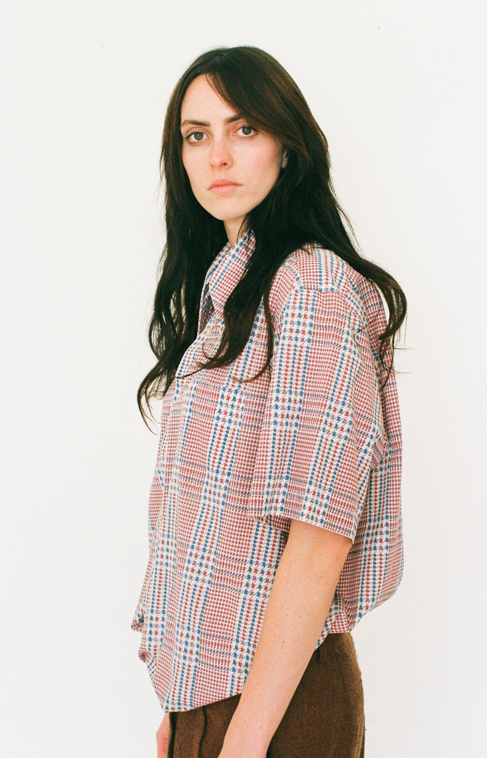 Woman wearing a plaid shirt against a white background