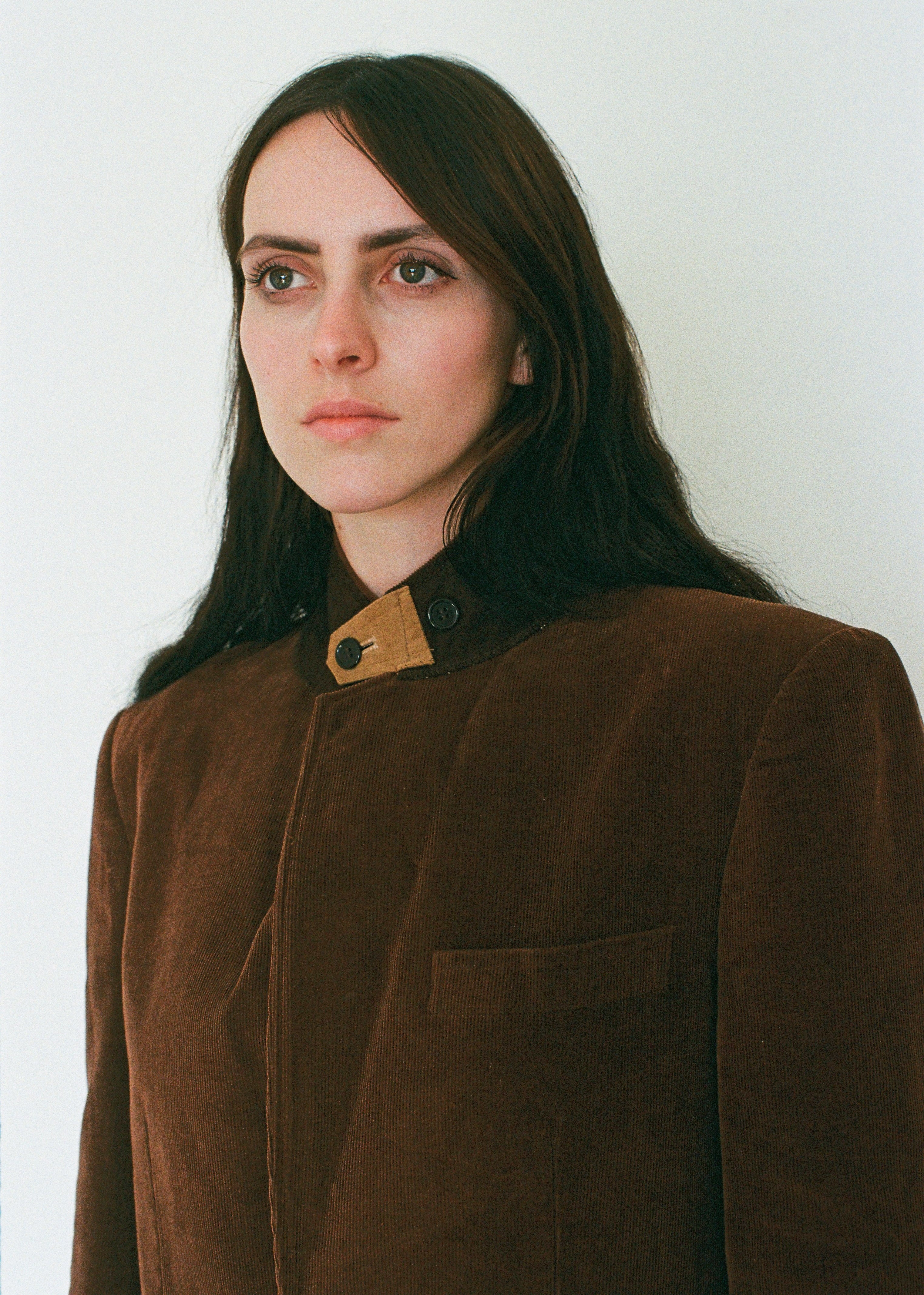 Woman wearing a brown coat with a white background