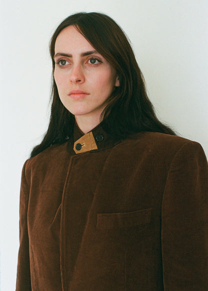 Woman wearing a brown coat with a white background