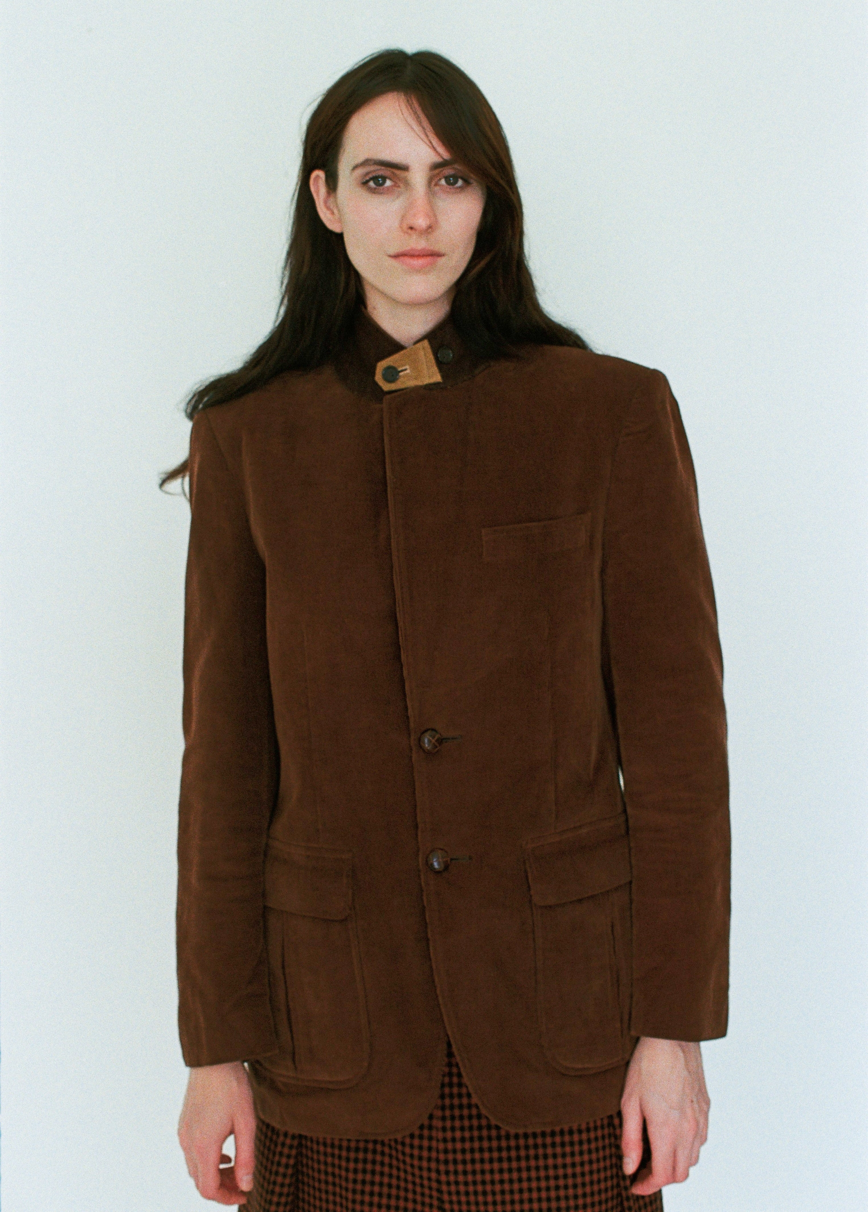 Woman wearing a brown jacket against a white background
