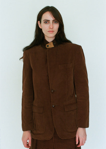 Woman wearing a brown jacket against a white background