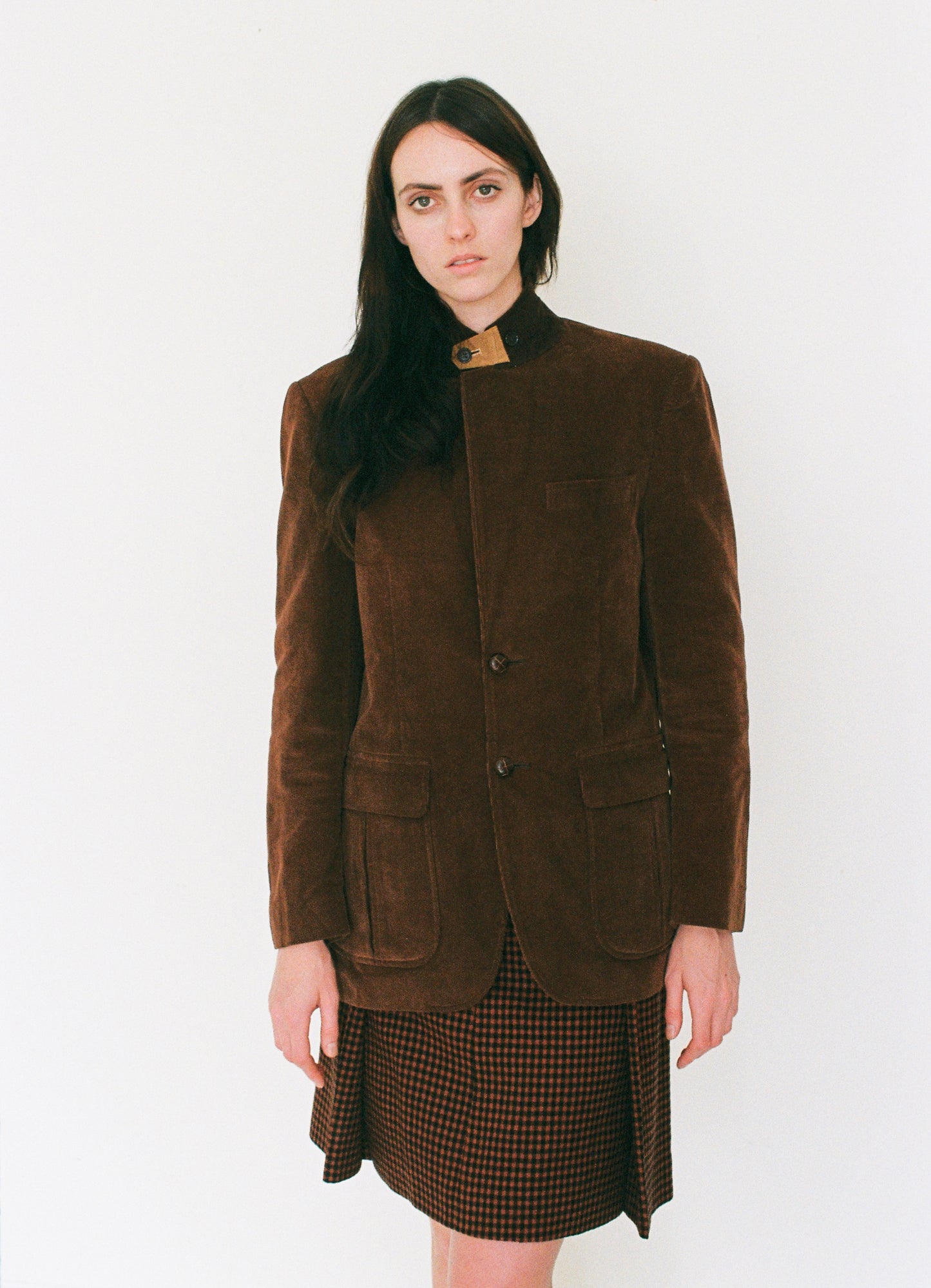 Woman wearing a brown jacket and skirt on a white background