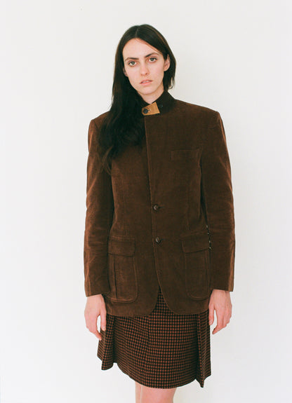 Woman wearing a brown jacket and skirt on a white background