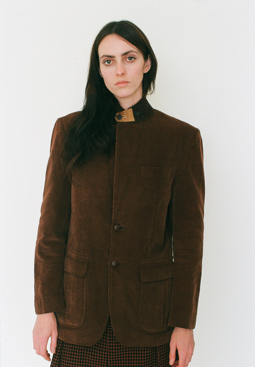 Woman wearing a brown jacket against a white background