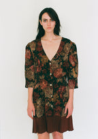 Woman wearing a patterned dress with a plain background