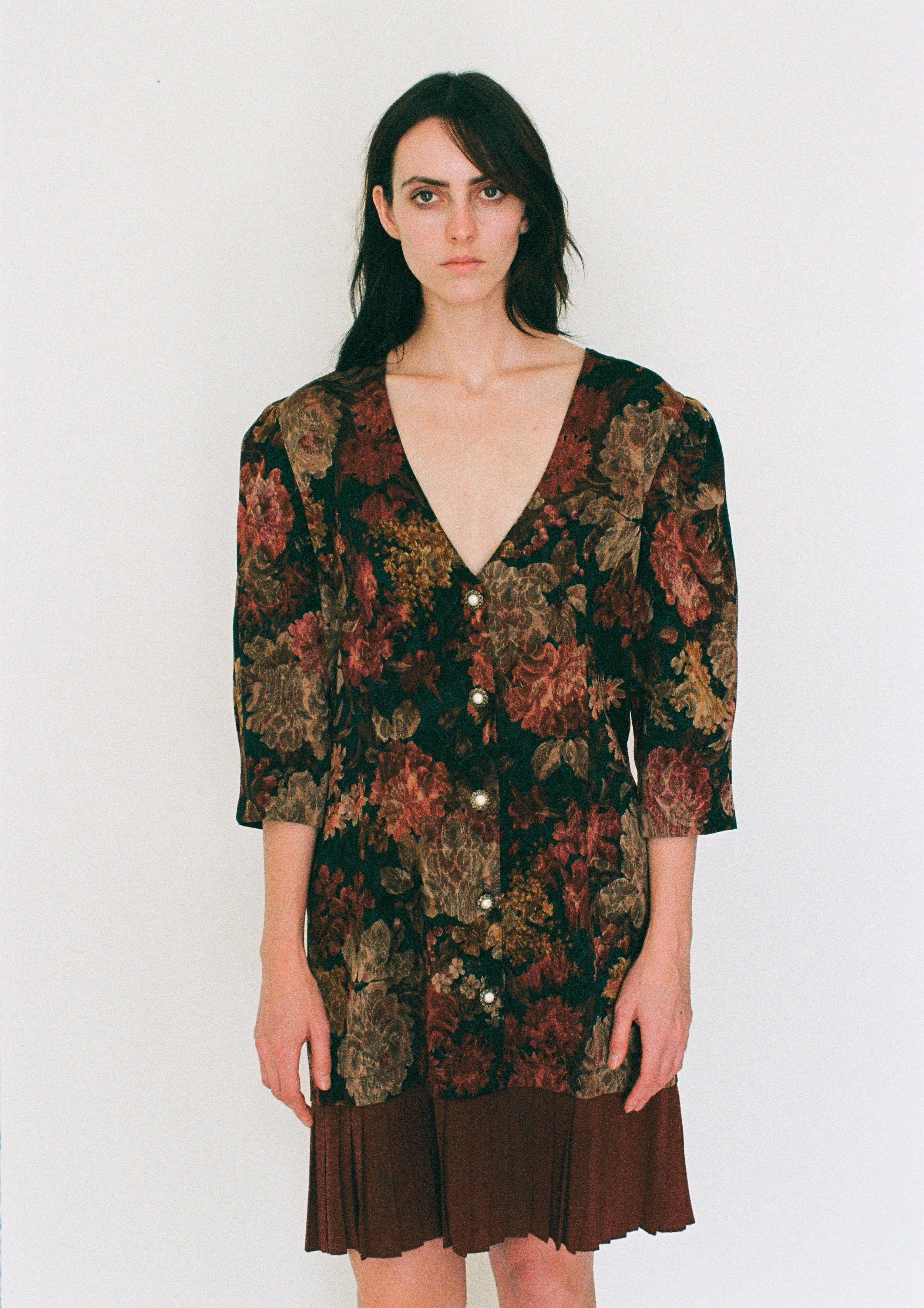 Woman wearing a patterned dress with a plain background