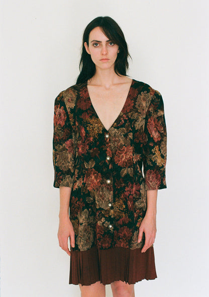 Woman wearing a patterned dress with a plain background