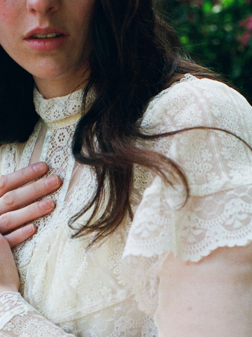 Woman wearing a white lace blouse with blurred background