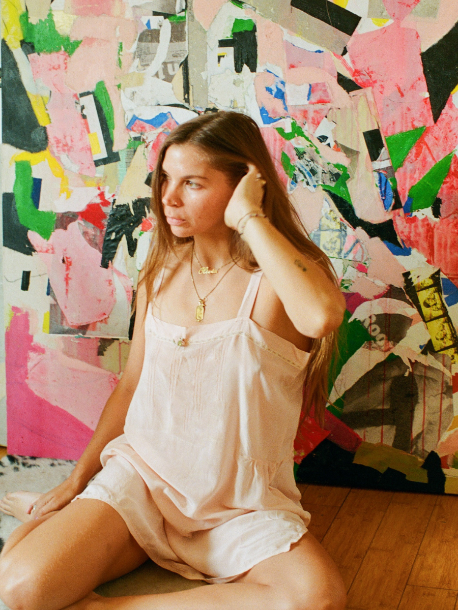 Woman sitting on the floor in front of a colorful abstract wall.