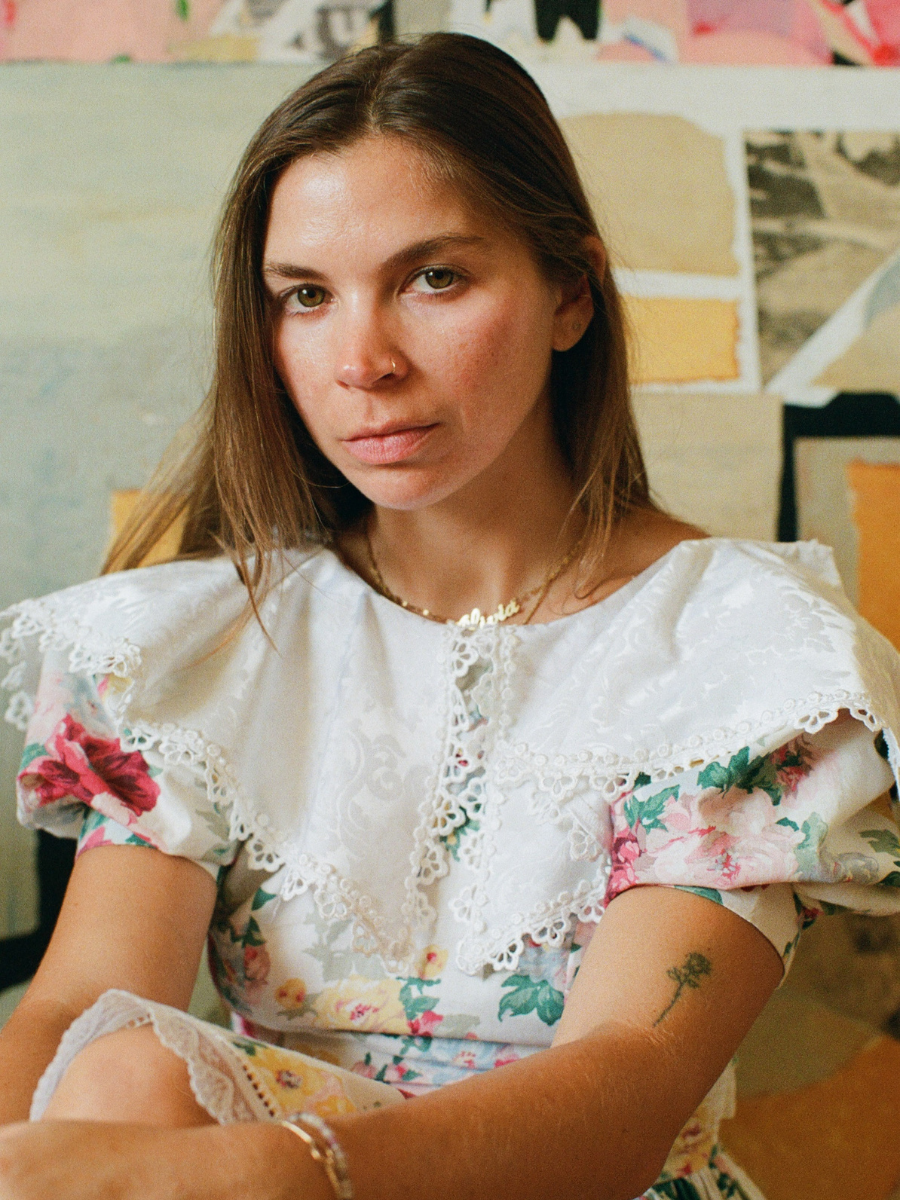 Woman wearing a white blouse with floral patterns in an indoor setting