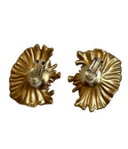 Pair of gold shell-shaped earrings on a white background