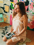 Woman holding books in a room with colorful abstract art on the wall.