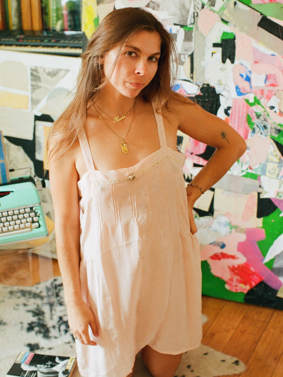 Woman in a light dress standing in front of a colorful abstract painting