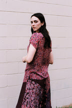 Woman wearing a floral dress against a beige wall
