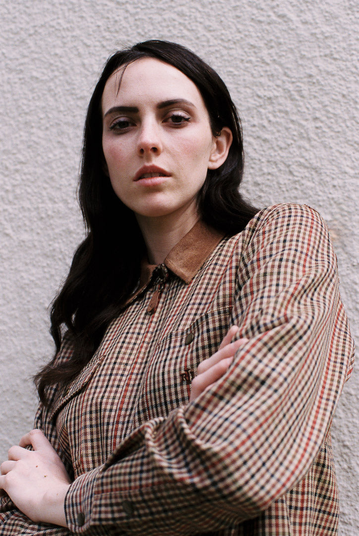 Woman wearing a plaid shirt against a plain background