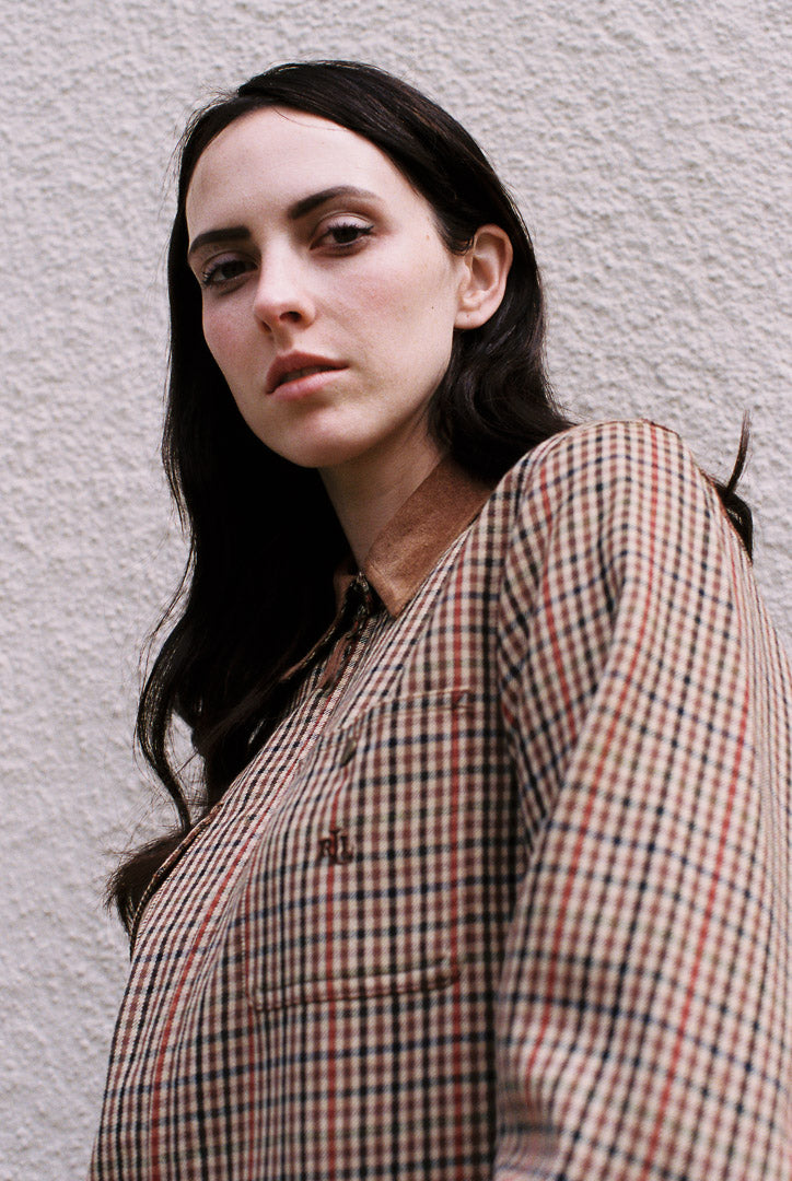 Woman wearing a plaid shirt against a plain background