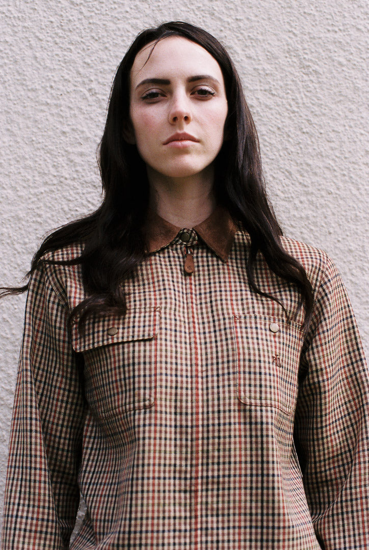 Woman wearing a plaid shirt against a plain background