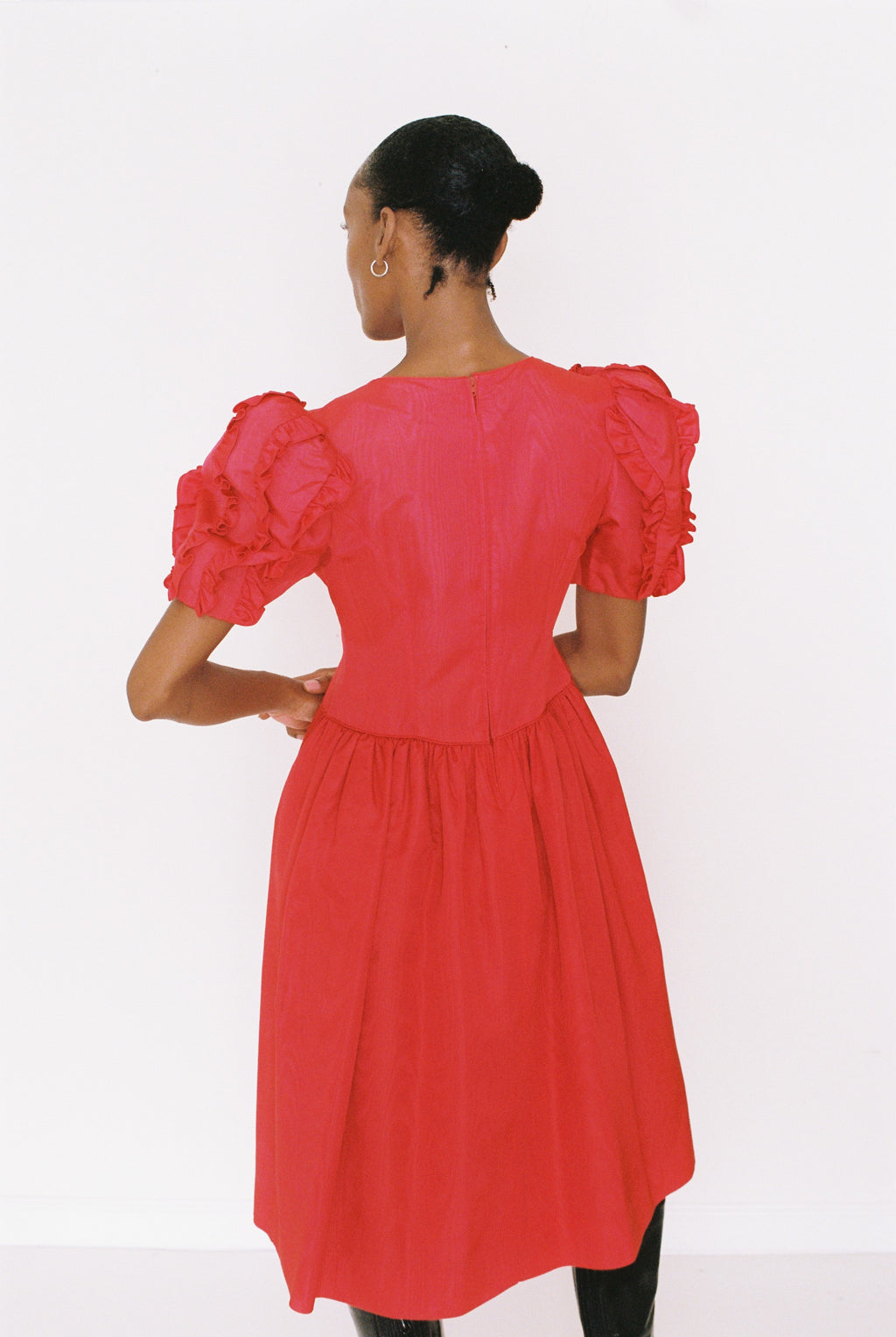 Red dress with puff sleeves worn by a person on a white background
