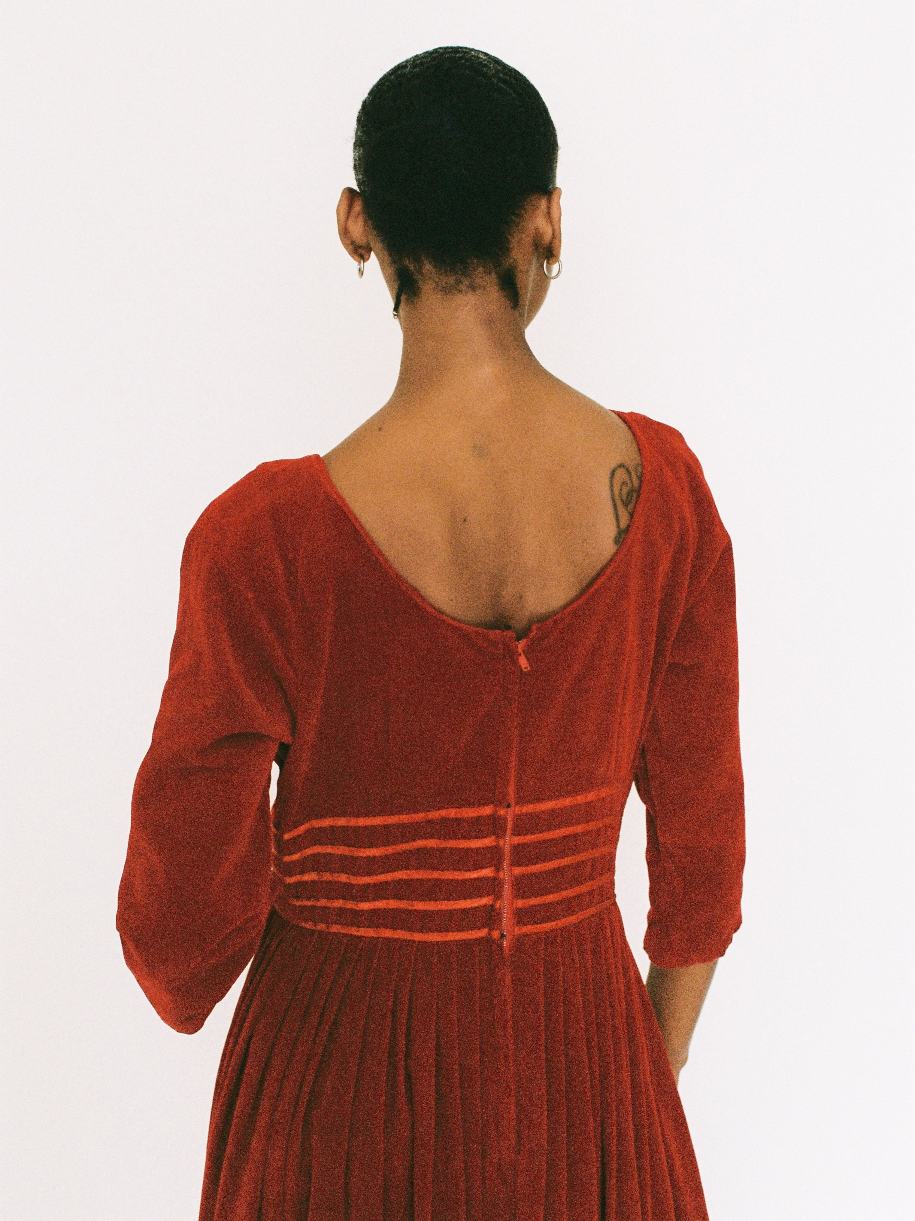 Red velvet dress with a fitted bodice and flared skirt on a plain background
