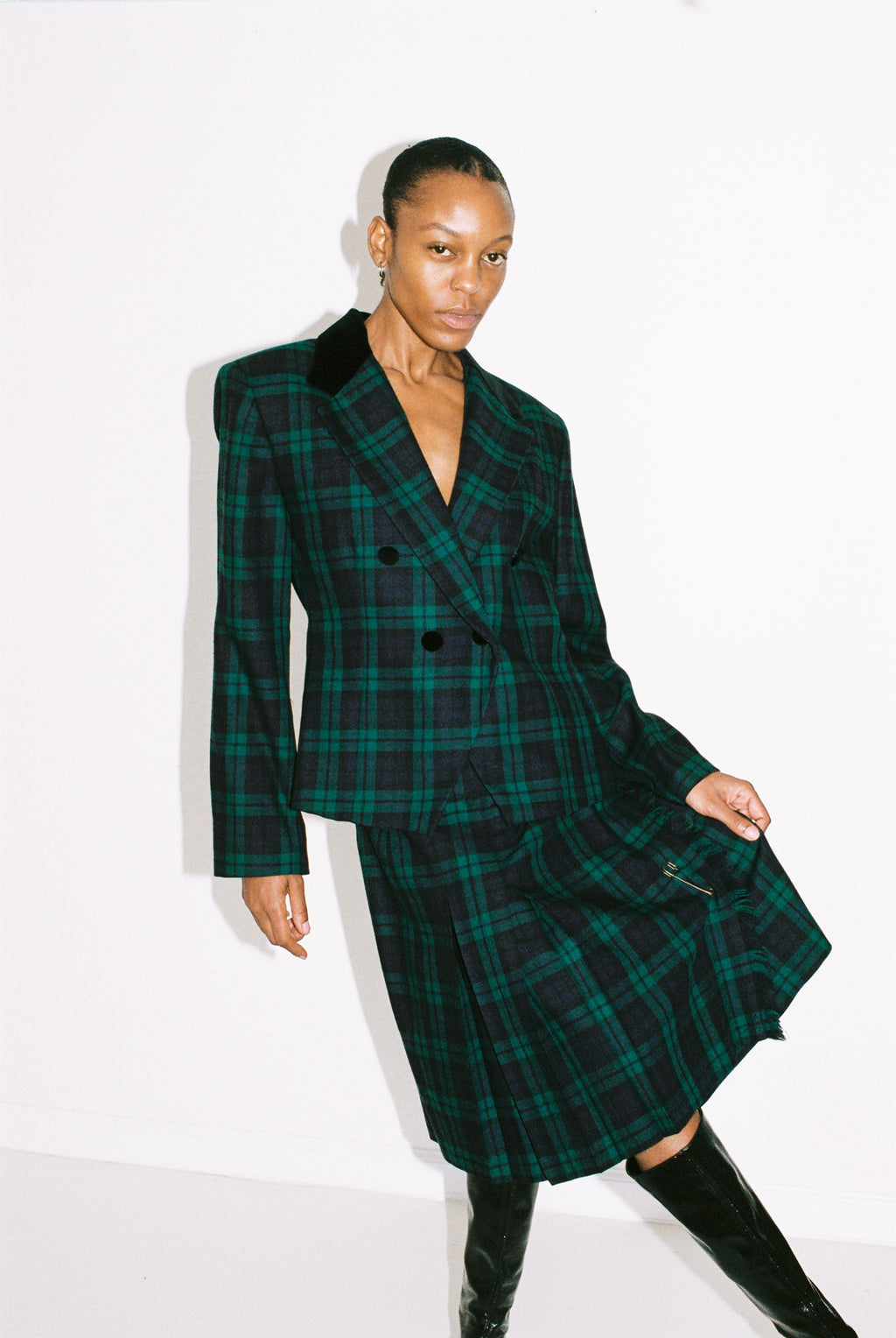 Person wearing a green plaid coat on a white background