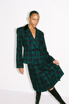 Person wearing a green plaid coat on a white background