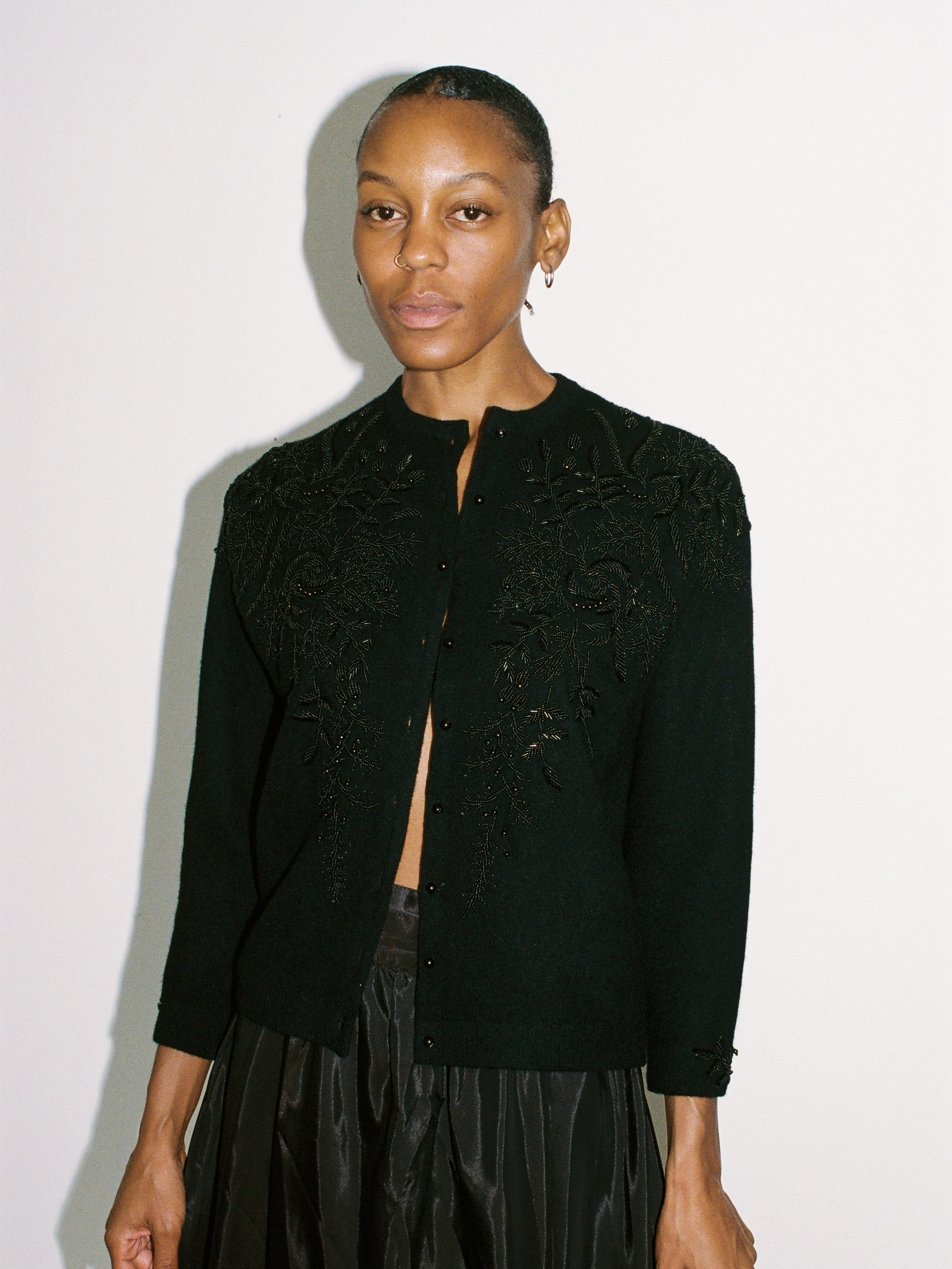 Woman wearing a black textured jacket against a white background