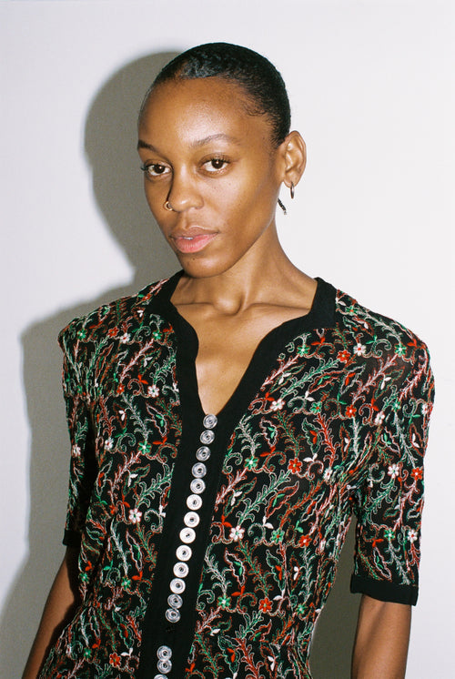 Woman wearing a patterned dress with a plain background