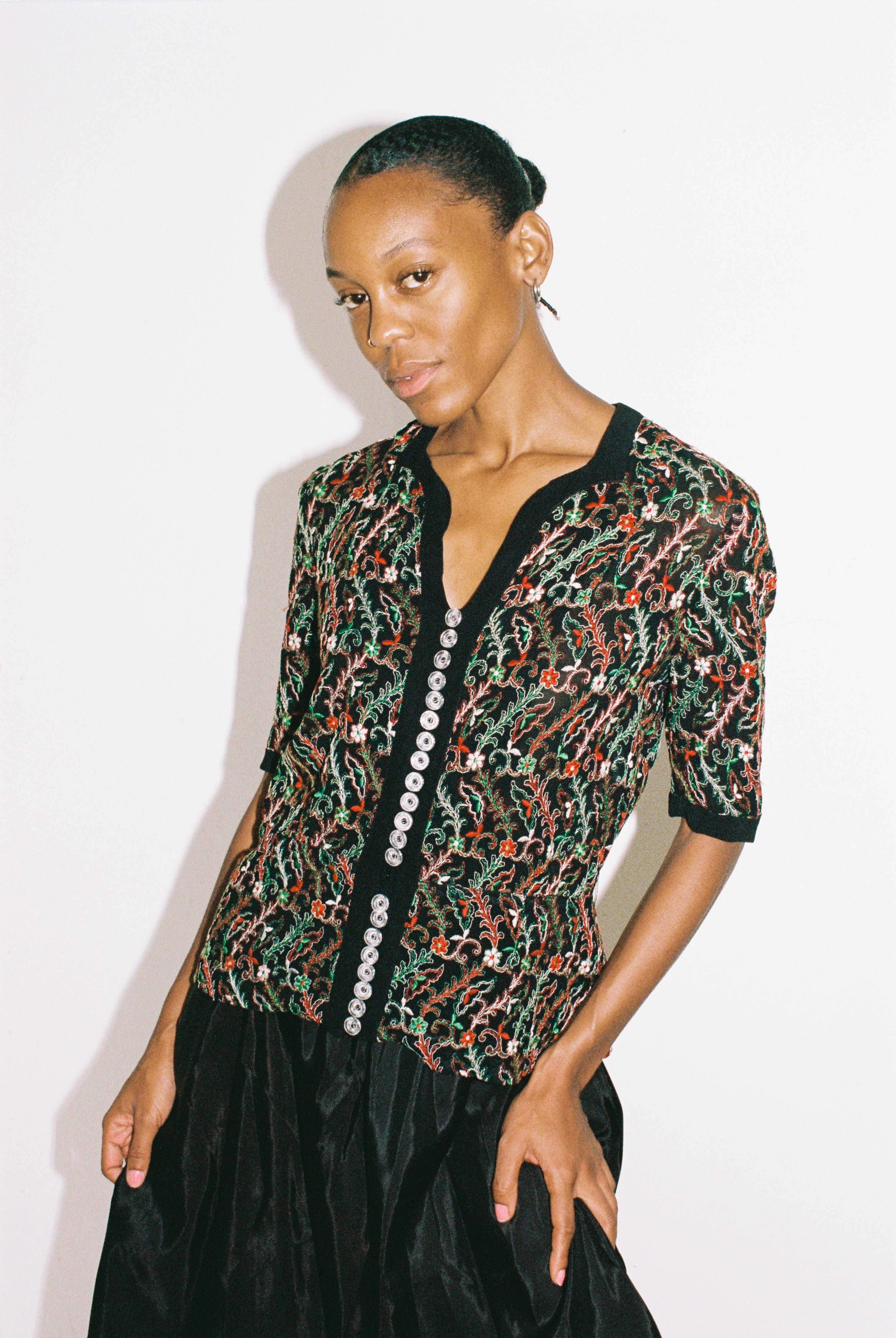Woman wearing a patterned top with a plain background
