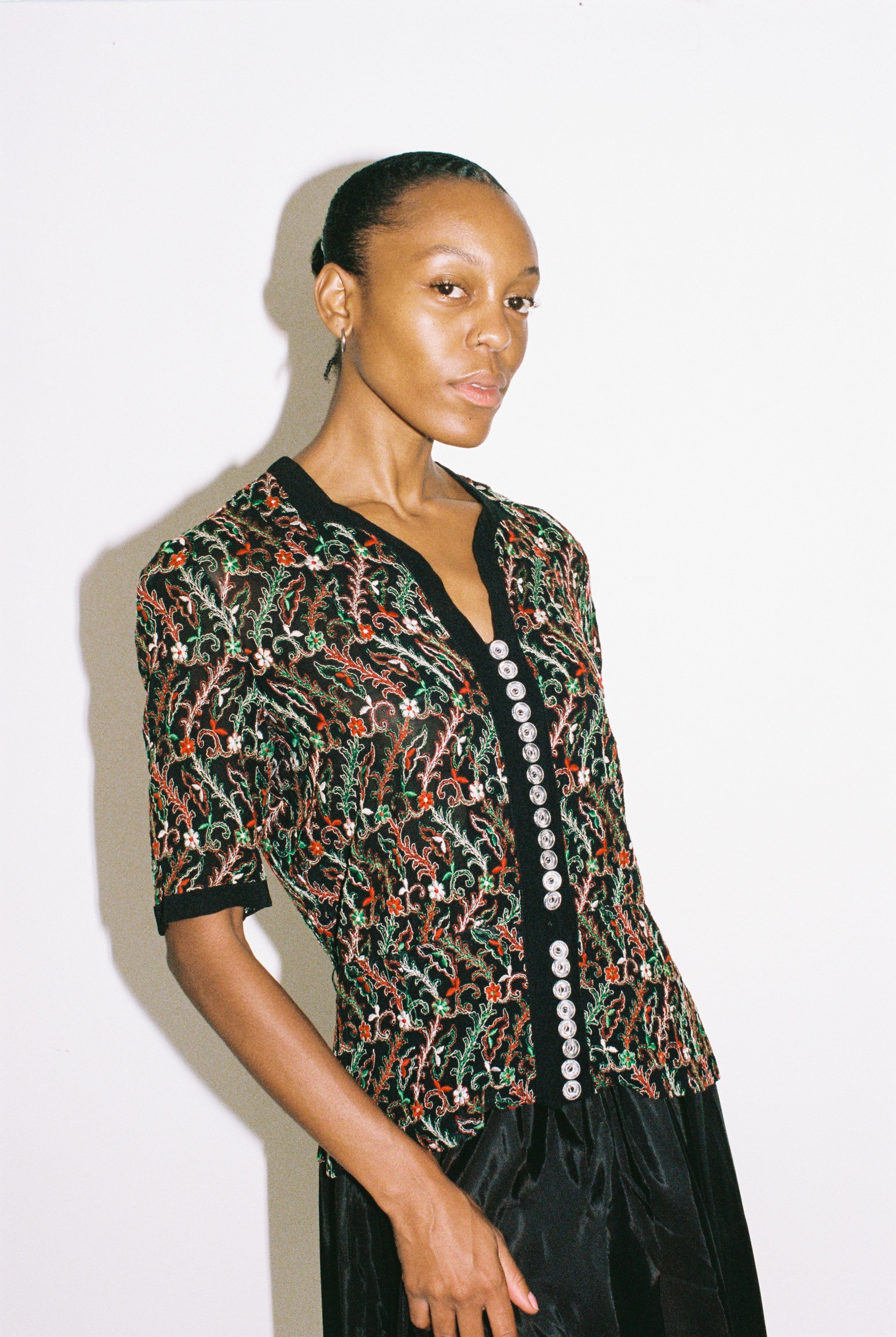 Woman wearing a patterned top with a plain background
