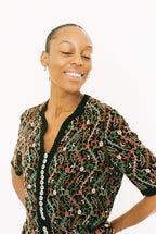 Woman wearing a patterned dress with a plain background