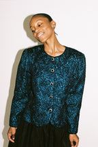 Person wearing a blue textured cardigan against a white background