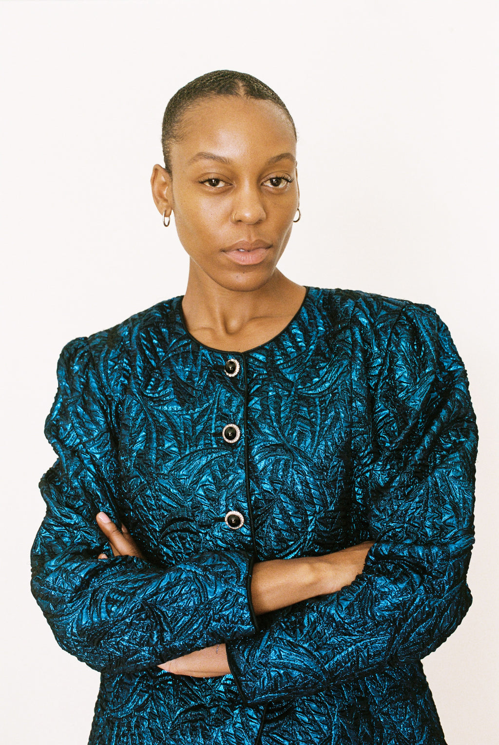 Woman wearing a blue patterned jacket against a white background