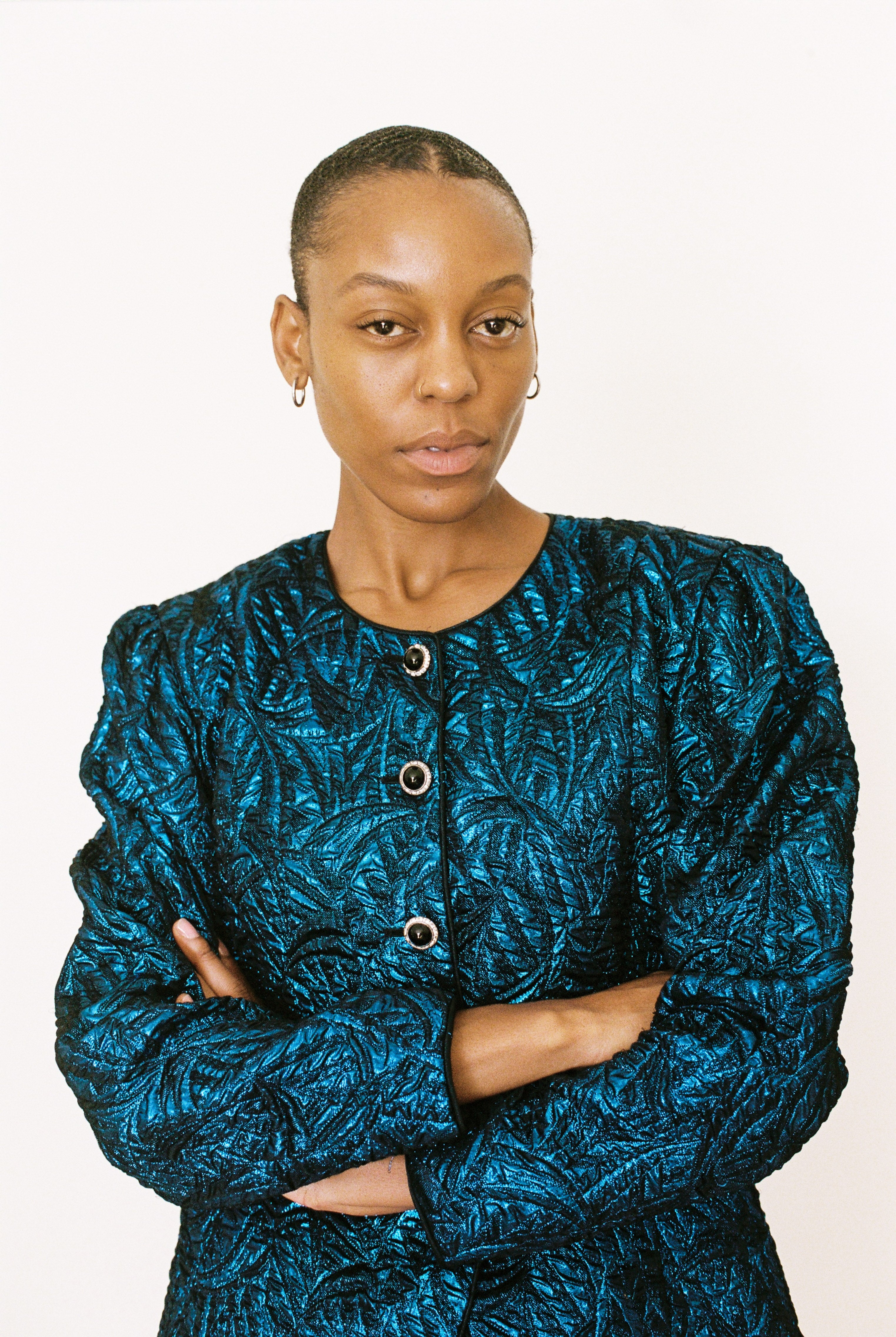 Woman wearing a blue patterned jacket against a white background