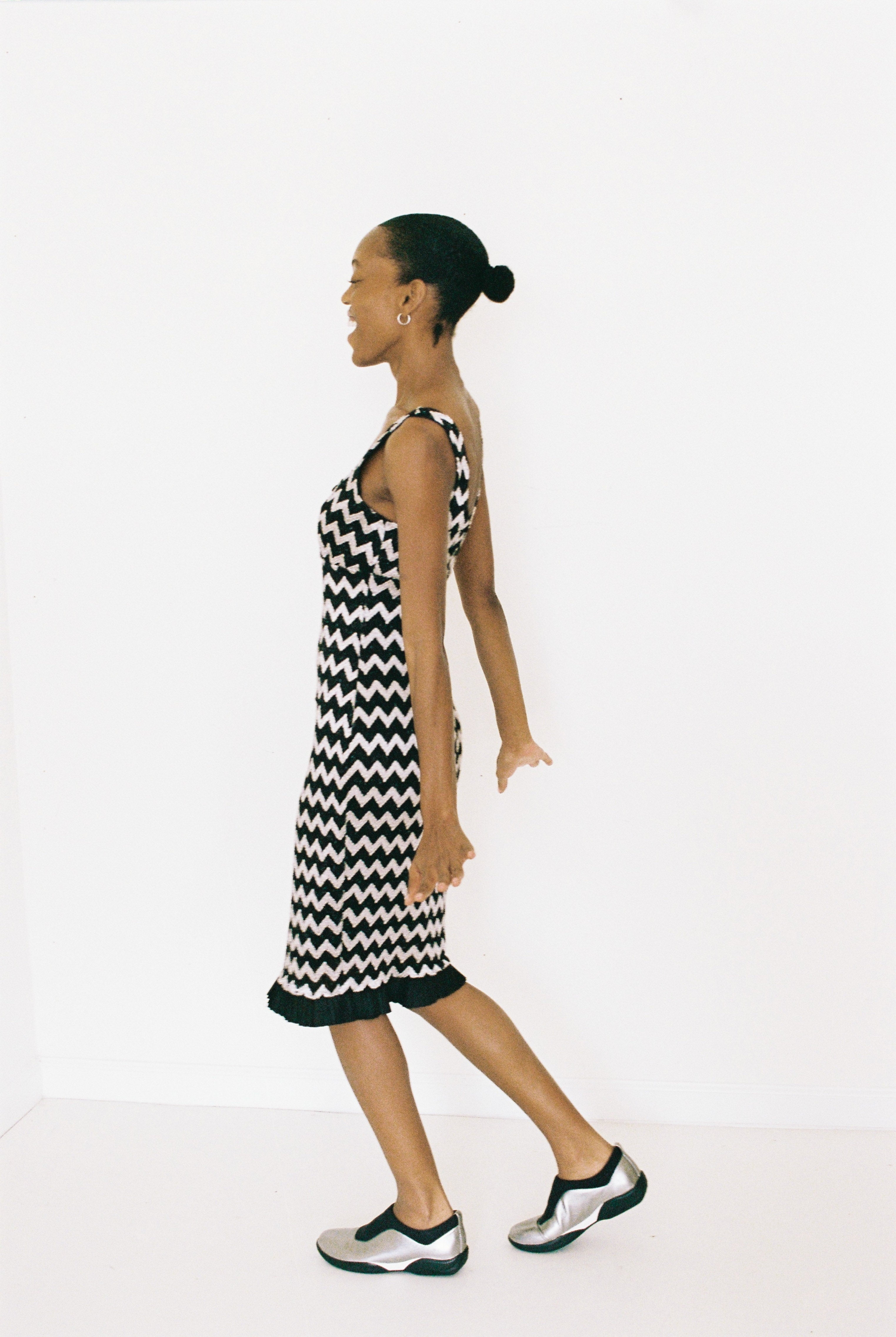 Woman wearing a black and white zigzag dress on a white background