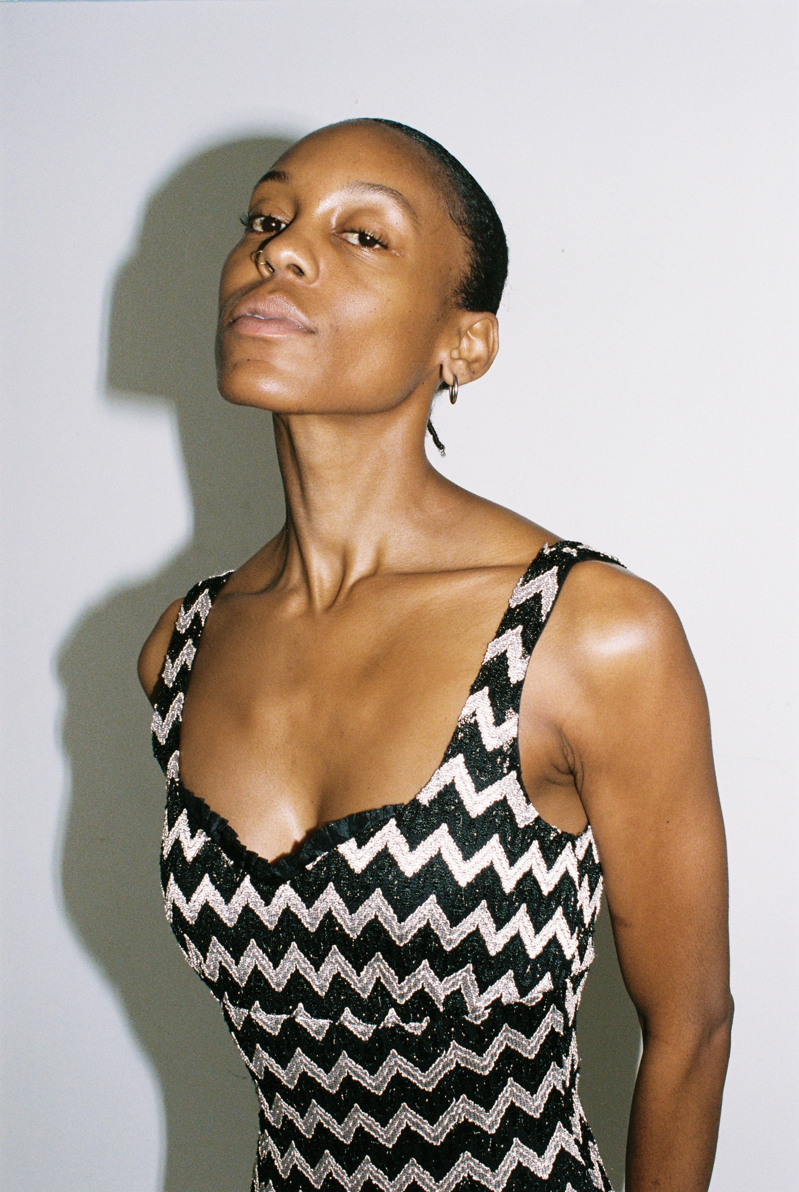 Woman wearing a black and silver zigzag patterned dress against a plain background