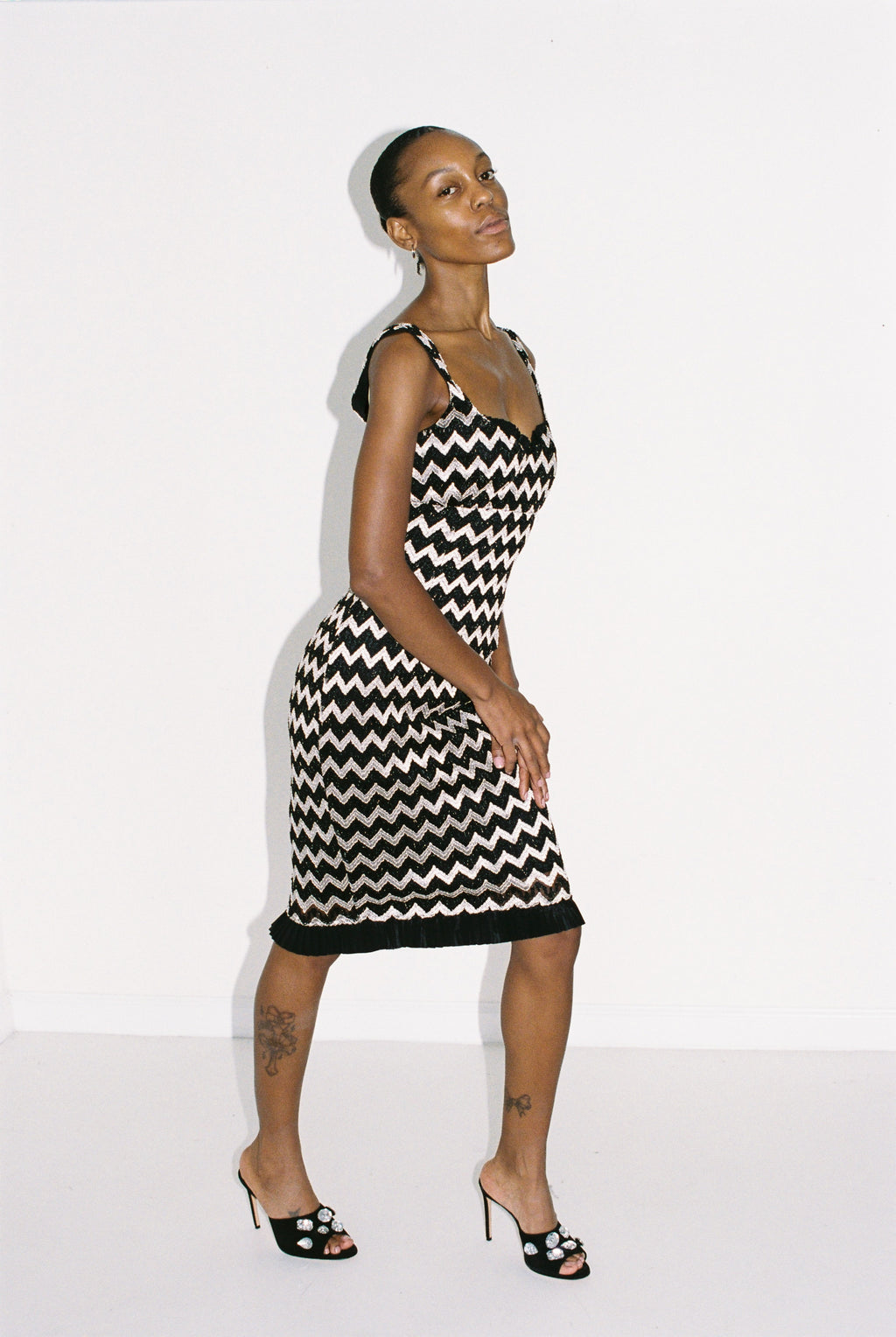 Woman wearing a black and silver zigzag dress against a white background