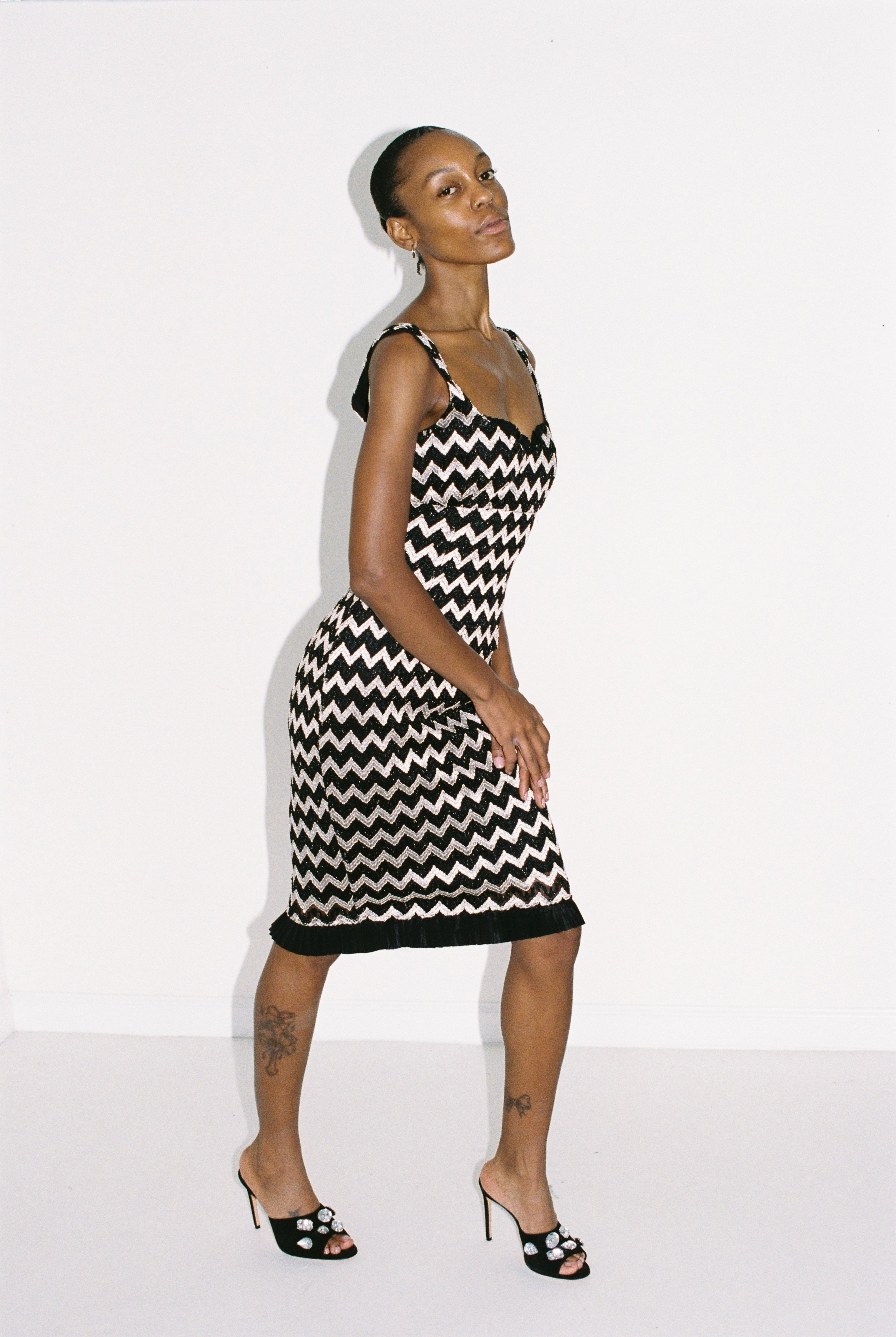 Woman wearing a black and silver zigzag dress against a white background